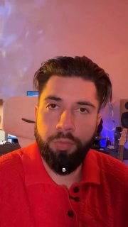 Средний план создателя контента в студии: человек с тёмной бородой и укладкой, на заднем плане световые эффекты и оборудование для записи музыки.