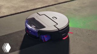 Черный робот‑пылесос Dyson Spot+Scrub AI на полу в студийном освещении, вид сбоку, с подсветкой датчиков и колесами, демонстрация дизайна устройства.