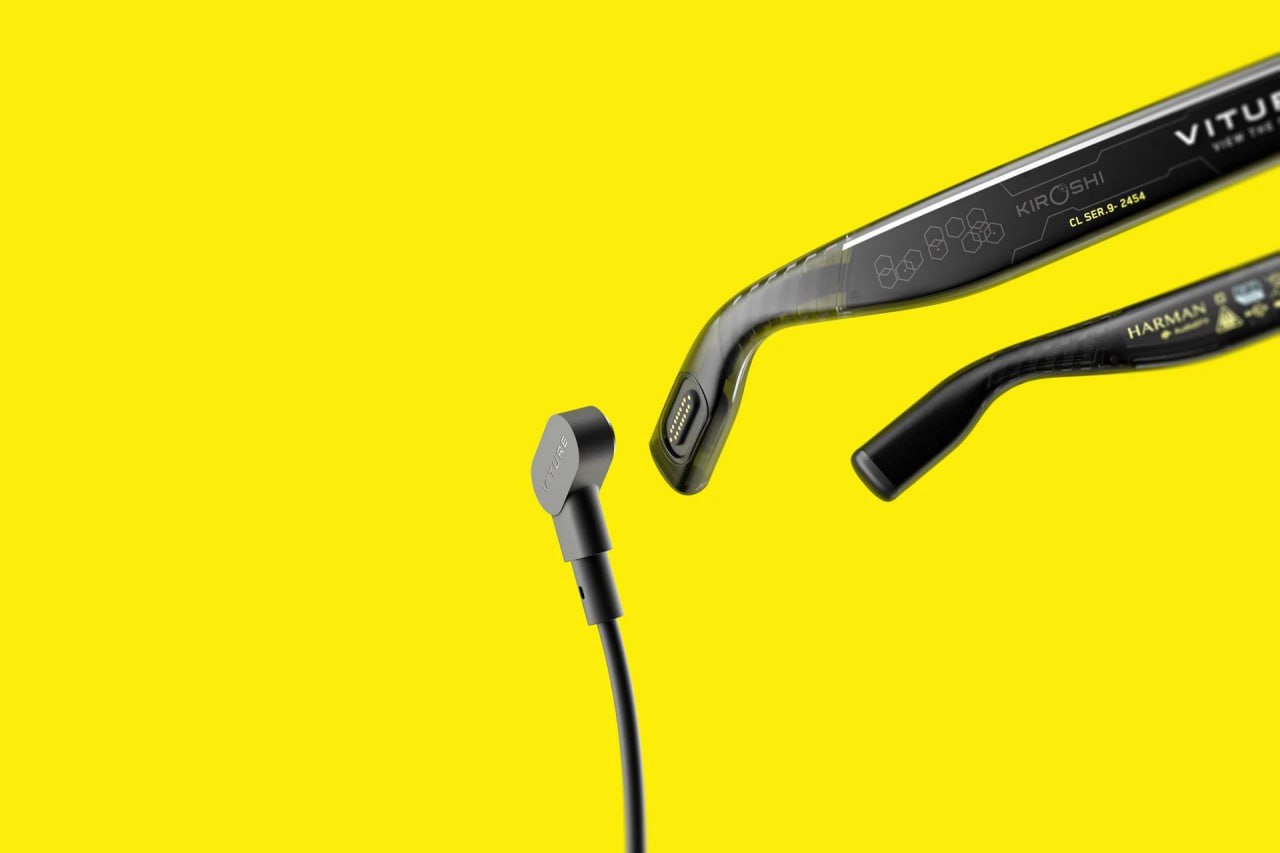 Крупный план задней части дужки и подключаемого кабеля или коннектора очков Viture на жёлтом фоне, видна текстура и детали соединения.