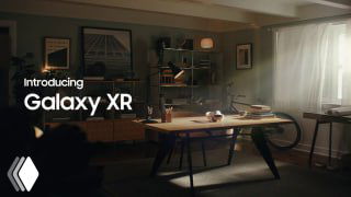 Рекламный кадр Galaxy XR: интерьерная сцена с рабочим столом и наложенными интерфейсными окнами, надпись "Introducing Galaxy XR" на экране.