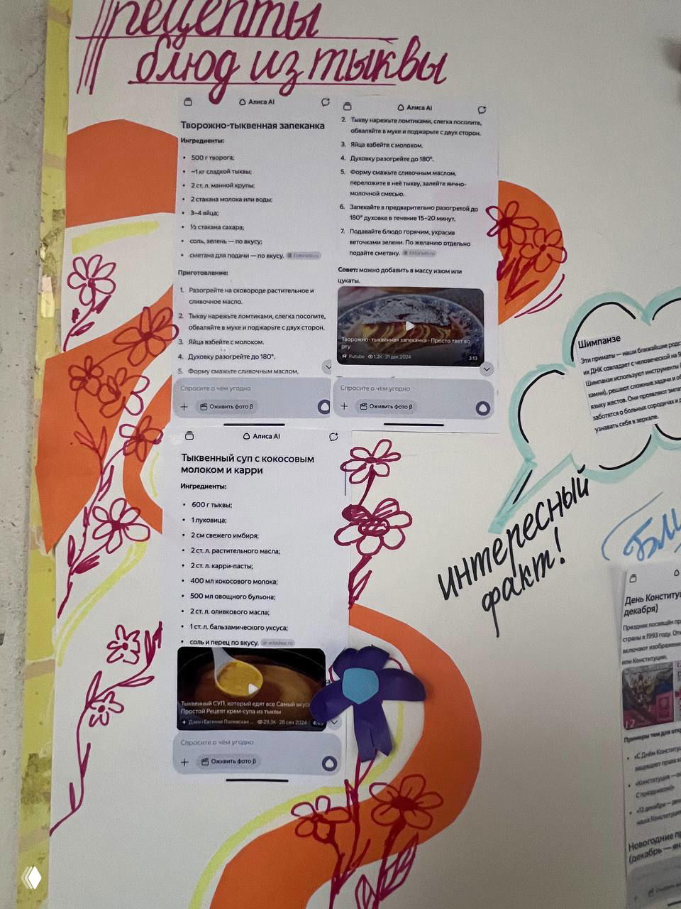 Крупный план секции стенгазеты с распечатанными рецептами и фотографиями блюд, украшенной ручными элементами и вырезанными цветами.