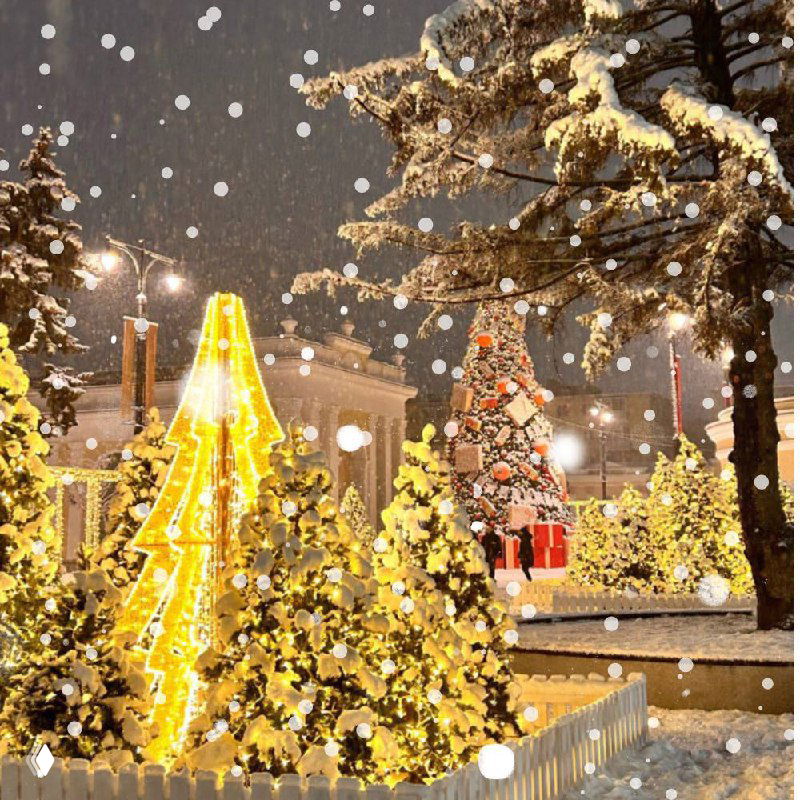 Праздничная уличная инсталляция с золотыми рождественскими ёлками и гирляндами, заснеженный городской декор ночью.