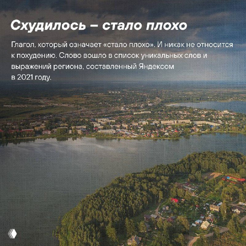 Осенний вид на старинный поселок у реки в Тверской области: купола, дома и разноцветные деревья вдоль берега.