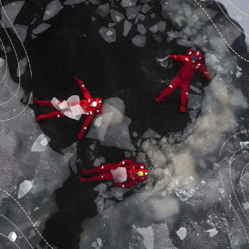 Группа людей в ярких зимних костюмах на льду у воды, демонстрирующая зимние активности и безопасное поведение на льду.