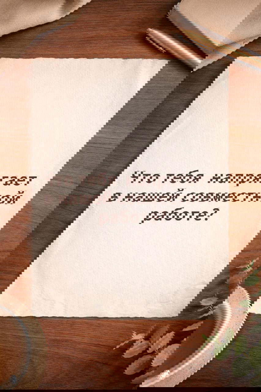 Лист бумаги с текстом «Что тебя напрягает в нашей совместной работе?», видна текстура бумаги и элементы канцелярии на столе.