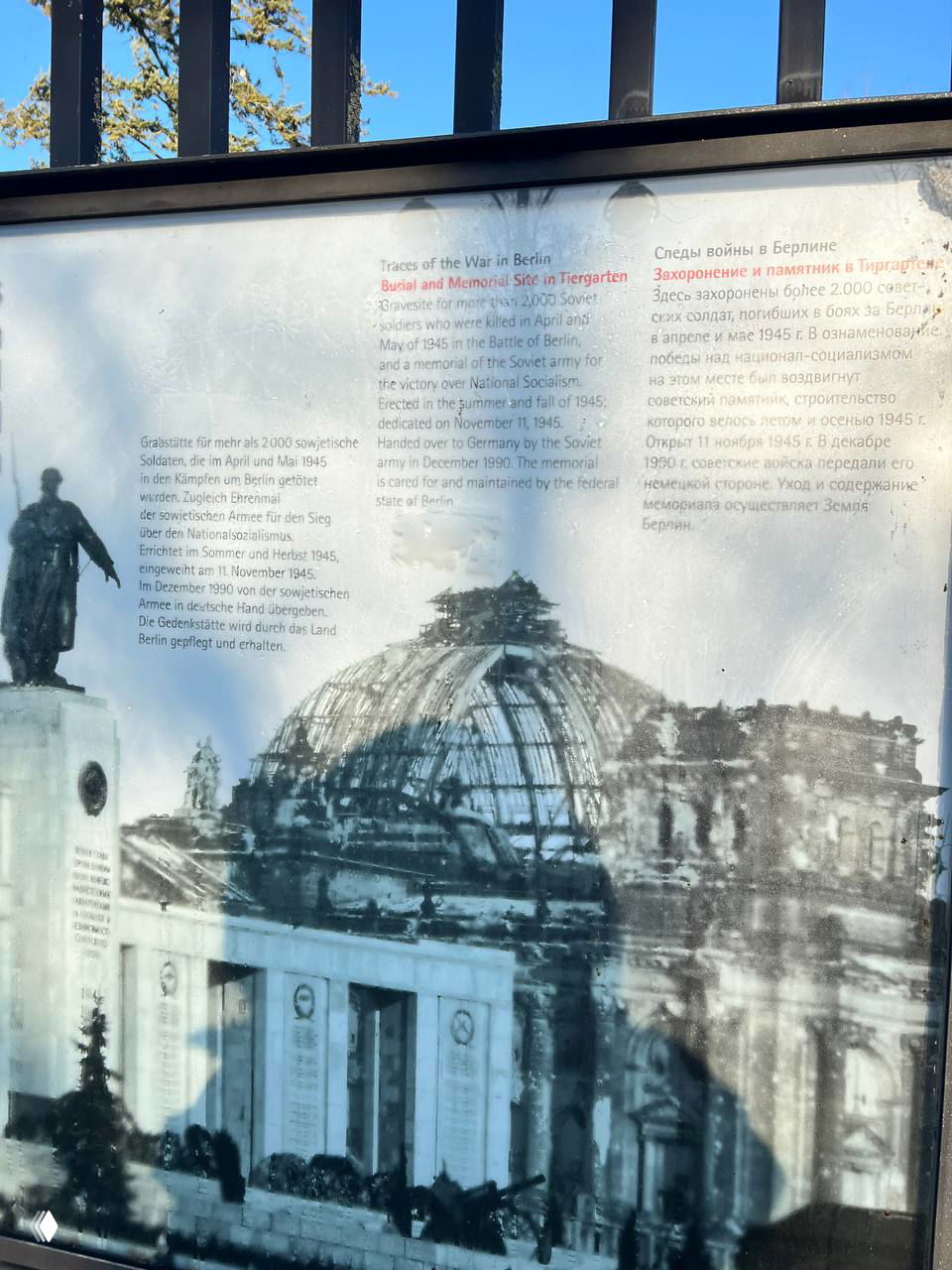 Информационная доска с архивным фото и текстом на русском и английском о следах войны в Берлине, просветы памяти и исторические сведения.