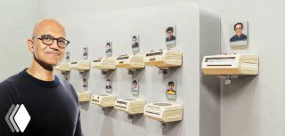Conceptual photo of a man by rows of small cubicle mailboxes, each holding a portrait — a visual metaphor for AI agents assigned to workplace cubicles.