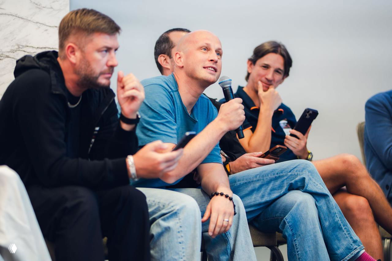 Audience members and mentors in discussion, a participant asking a question while holding a microphone during the hackathon session.