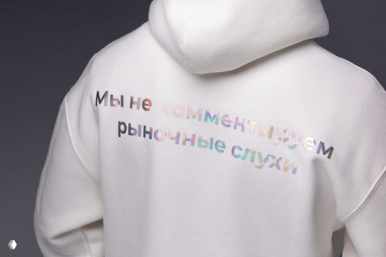 Белый худи с радужной надписью на спине «Мы не комментируем рыночные слухи» — другй ракурс мерча Ночной PR‑директор