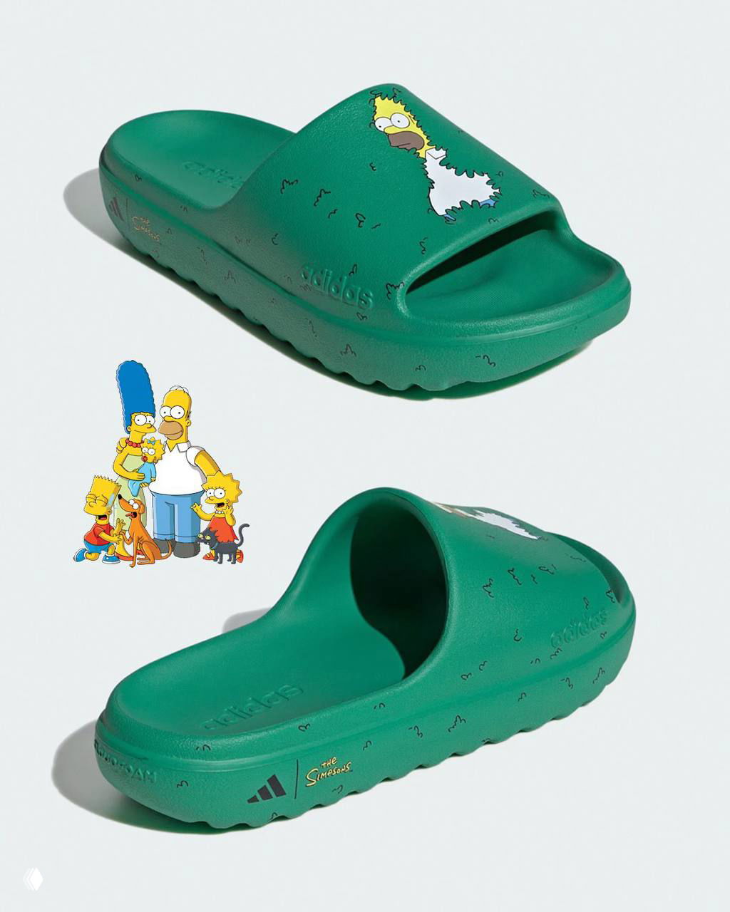 Крупный план одного зеленого слайда adidas Adilette с иллюстрацией Гомера в кустах; заметна текстура материала и рельефный логотип бренда на борту.