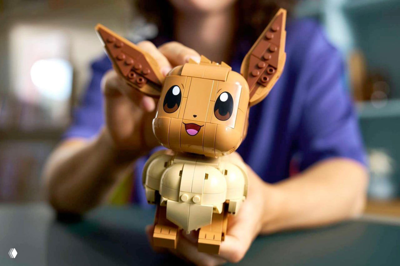 Крупный план собранного набора Lego — Иви (Eevee) в руках человека; хорошо видны детали конструкции и дизайн фигуры.