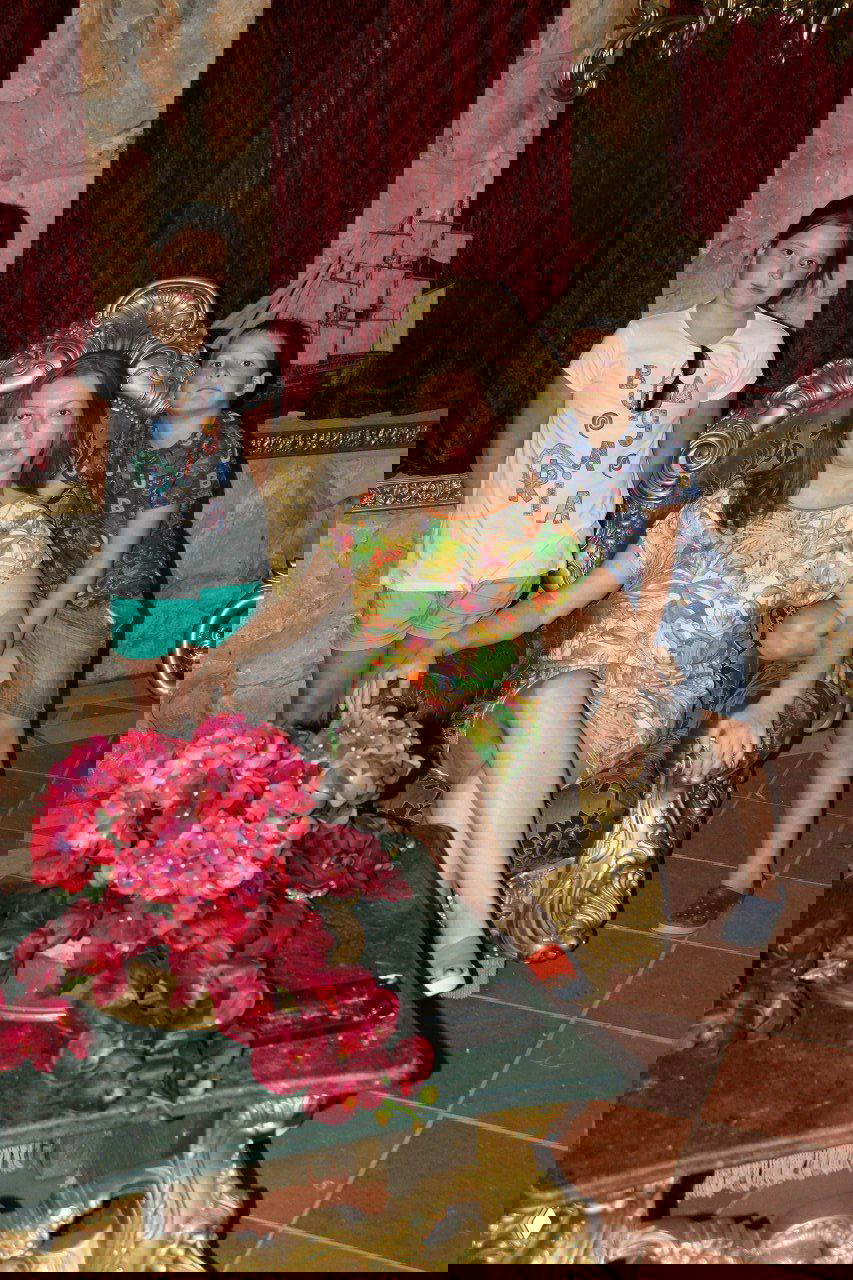 Женщина сидит в декоративном кресле рядом с двумя детьми в интерьере с каменной отделкой и декоративным кораблем, семейная сцена во время отпуска.