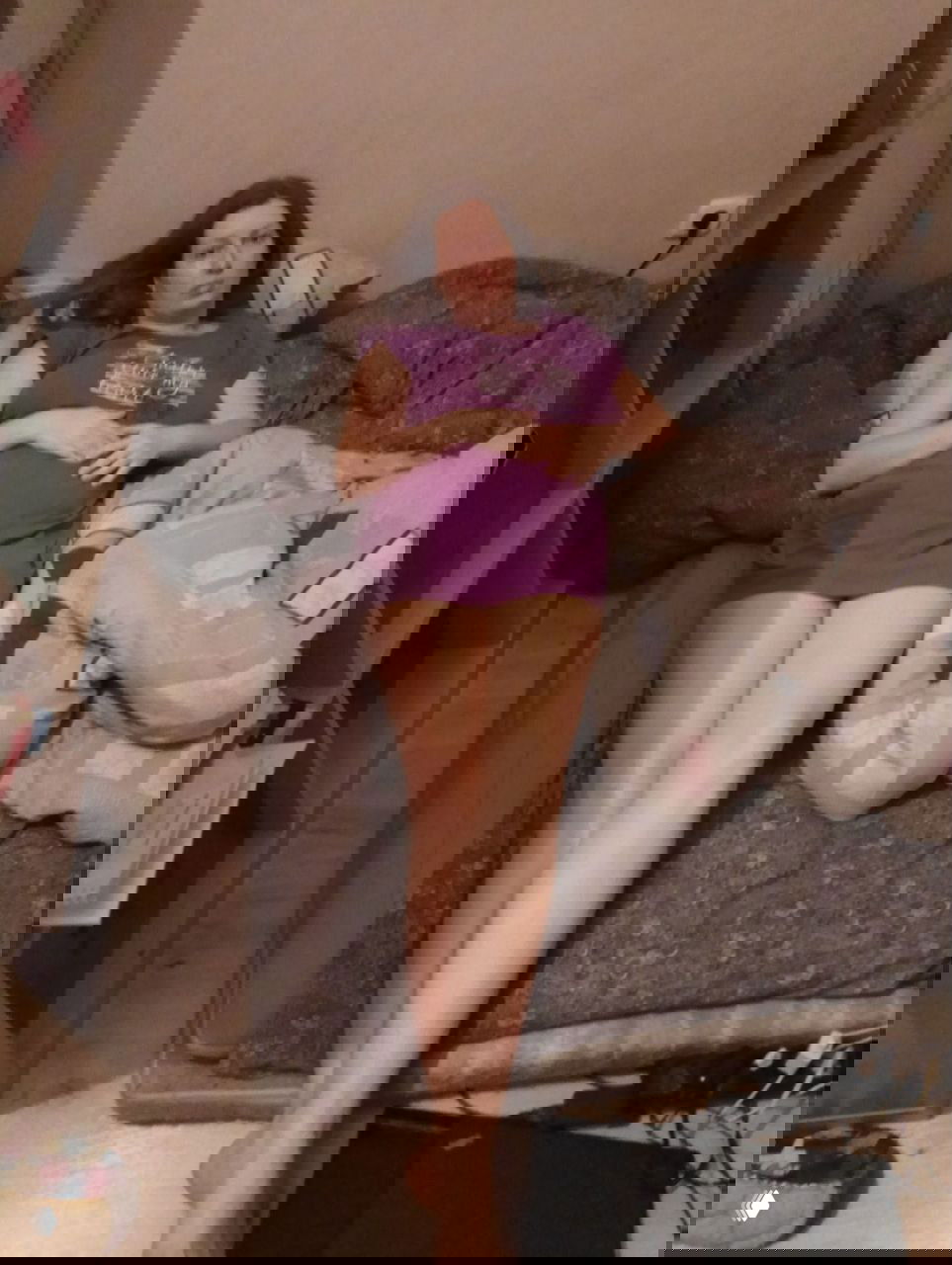 Женщина в домашней одежде лежит на матрасе в спальне; видны одеяло, пол и книжная полка — интимный кадр трансформации пространства.