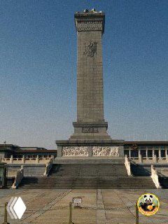 Высокий монумент на большой площади, массивная колонна и широкая открытая плоскость перед ним, символическая городская точка ориентира.