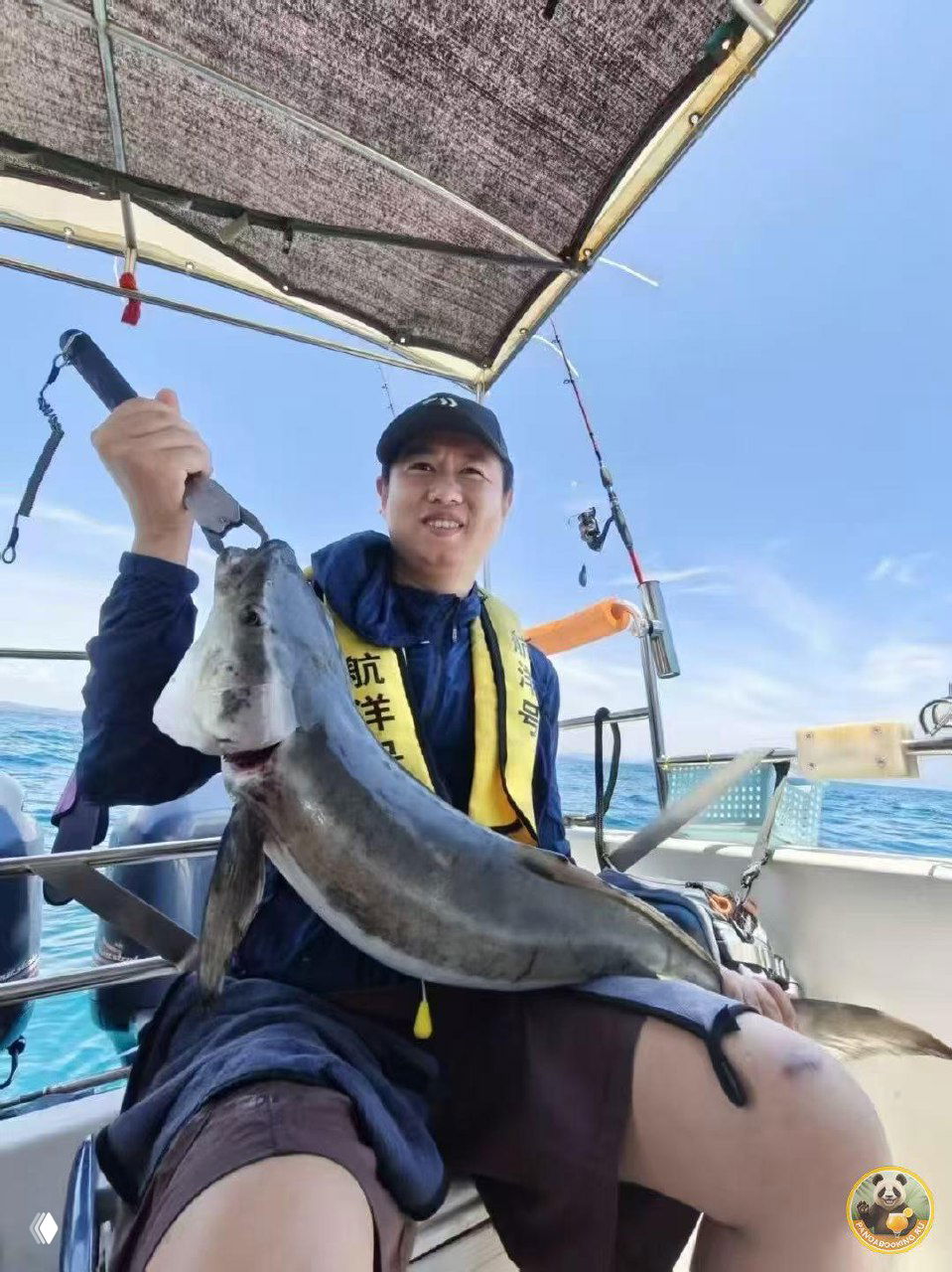 Пассажиры на палубе рыболовного катера держат пойманную рыбу и удочки на фоне открытого моря — бытовая сцена морской рыбалки и чартерной прогулки.