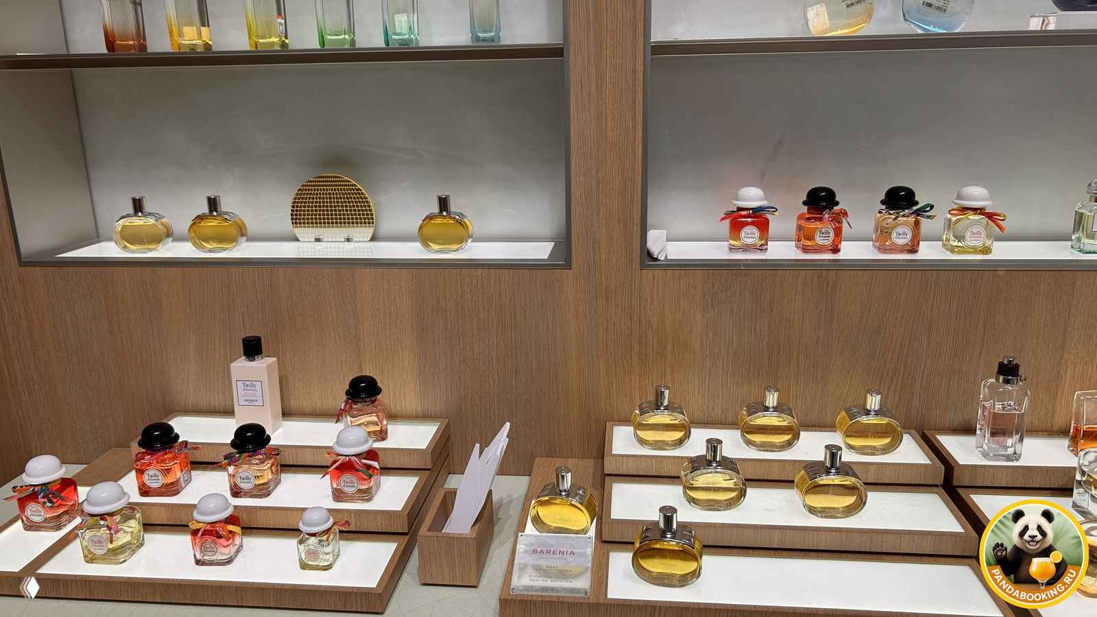 Стеллажи с мини-флаконами и тестерами парфюмов на подсвеченных деревянных полках в разделе нишевой парфюмерии.