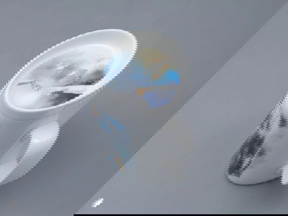 Фарфоровая кружка и крышка с иллюстрациями из Atomic Heart: рисунок внутрь крышки и принт на корпусе кружки, вид сверху.