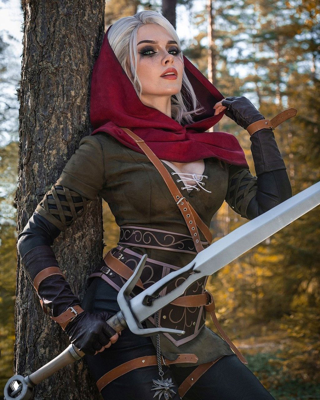 Крупный план: Илона Бугаева как Цири у ствола дерева, выразительный мейкап, детали ремней, рука на эфесe меча