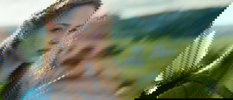 Официальный кадр из экранизации The Legend of Zelda: актриса в образе Зельды на фоне зелёного пейзажа, костюм и антураж фэнтези.