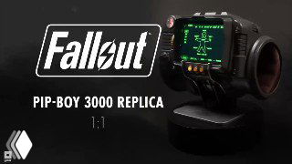 Реплика Pip‑Boy 3000 от Bethesda на подставке — демонстрационный снимок с видимым зелёным экраном устройства и логотипом Fallout на тёмном фоне.