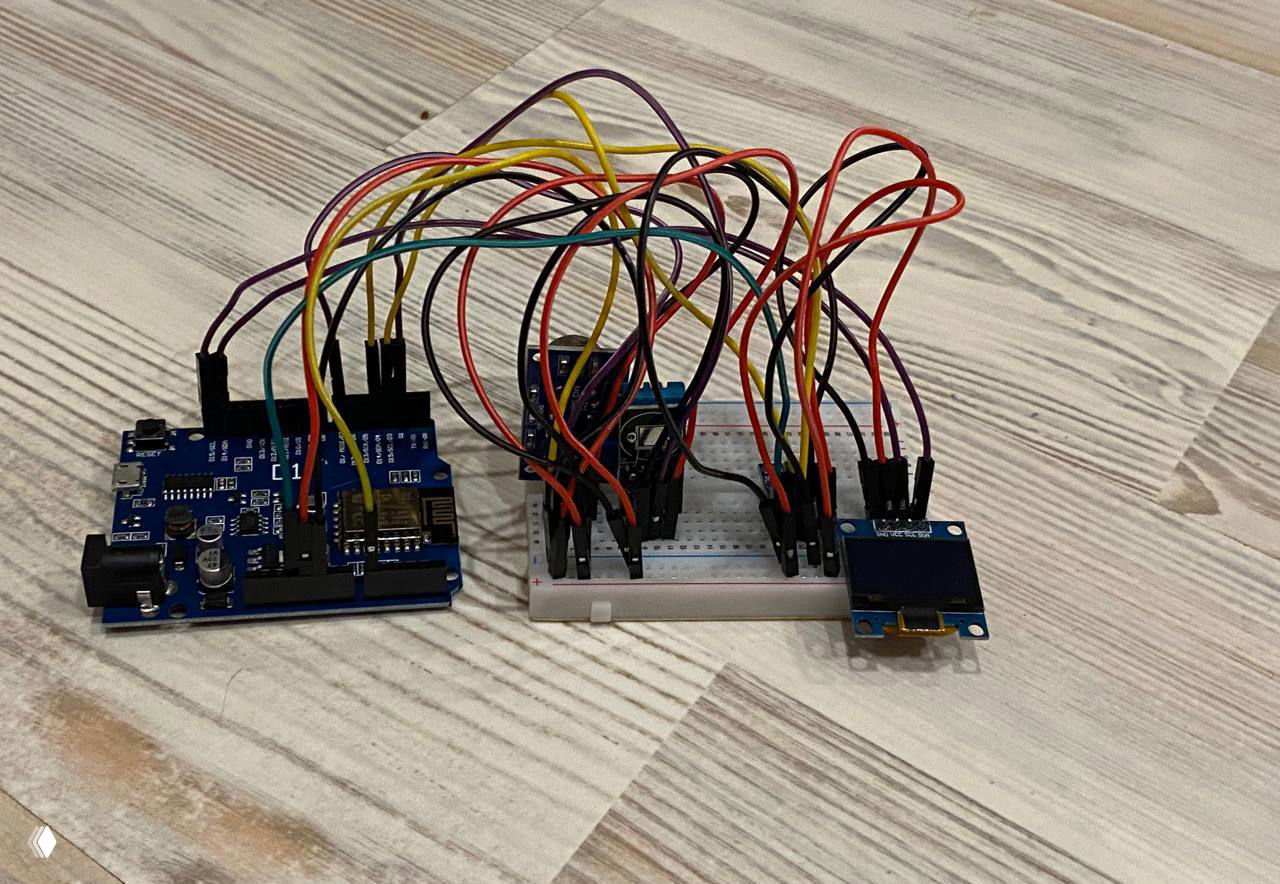 Фото прототипа метеостанции: макетная плата, модуль Arduino, множество соединительных проводов, датчики и маленький OLED‑дисплей.