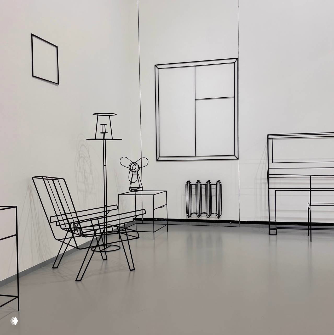 Инсталляция из чёрных металлических линий и проволочных контуров: кресло, торшер, вентилятор и радиатор создают схематичную комнату в белом зале музея.