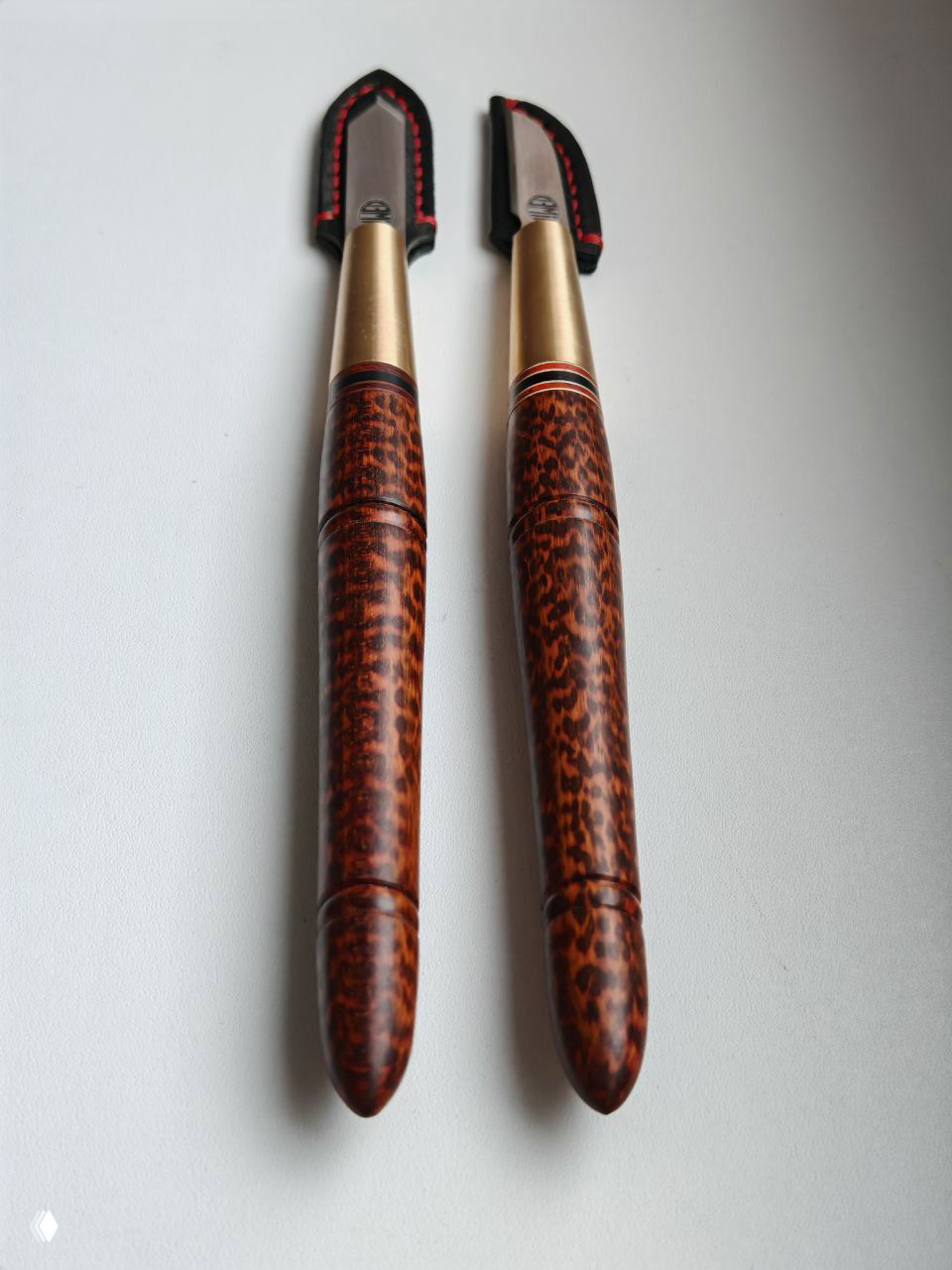 Парные разметочные ножи, расположенные параллельно: видно различие профилей рукоятей и единый декоративный стиль