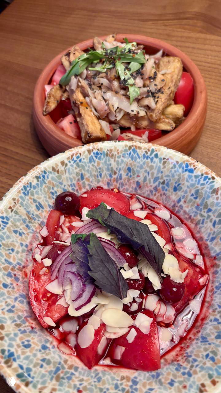 Керамическая посуда с закуской: миска с тёплыми картофельными дольками и зеленью на деревянном столе в уютной сервировке.