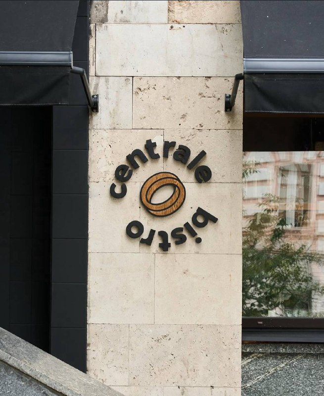 Фасад ресторана с вывеской centrale bistro на каменной стене, уличный ракурс входа и элементы городской среды вокруг заведения