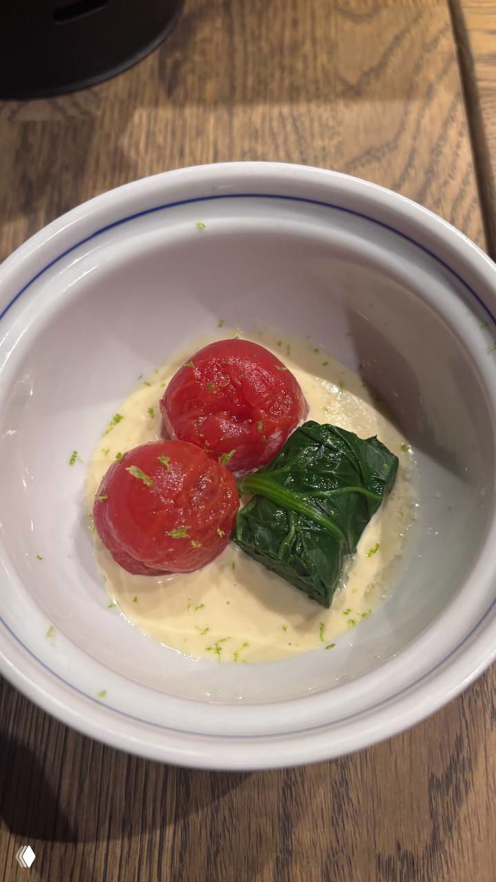 Порция маринованных томатов в белой миске с листом шпината на кремовом соусе — простая и яркая закуска из сета Kyomei.