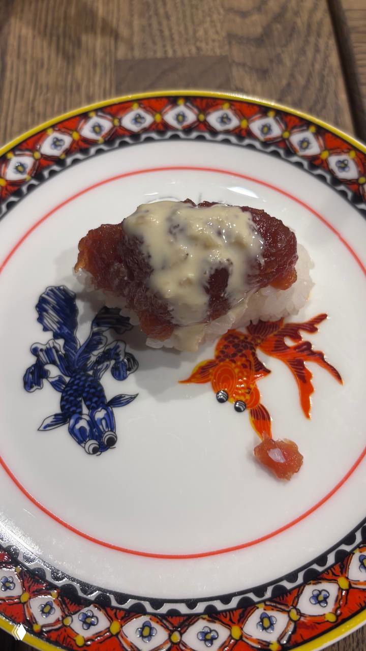 Нигири на декоративной тарелке: кусочек рыбы или морепродукта сверху риса с легким соусом, подается как часть омакaсе-сета.