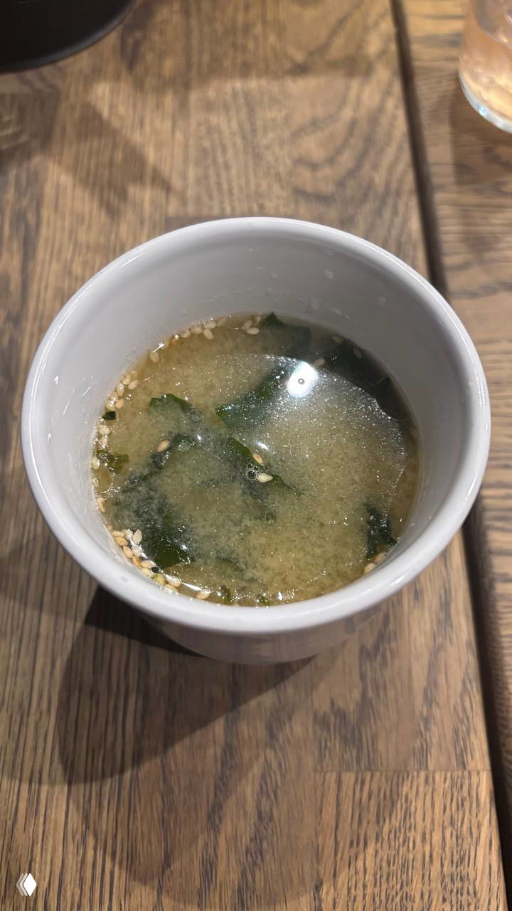 Мисо-суп в белой кружке с кусочками водорослей и кунжутом на поверхности — традиционный элемент сета Kyomei.