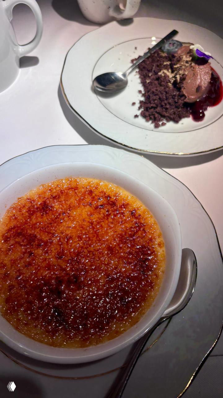 Яркий тёмно-розовый десерт в сливочном соусе на белой тарелке, минималистичная элегантная подача и контраст текстур в финальной части ужина.