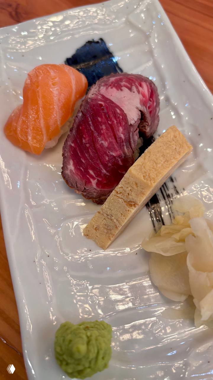 Нигири: кусочки лосося, ростбифа и кусочек тамаго на белой тарелке с васаби и маринованным имбирём — эстетичная подача суши-ассорти.