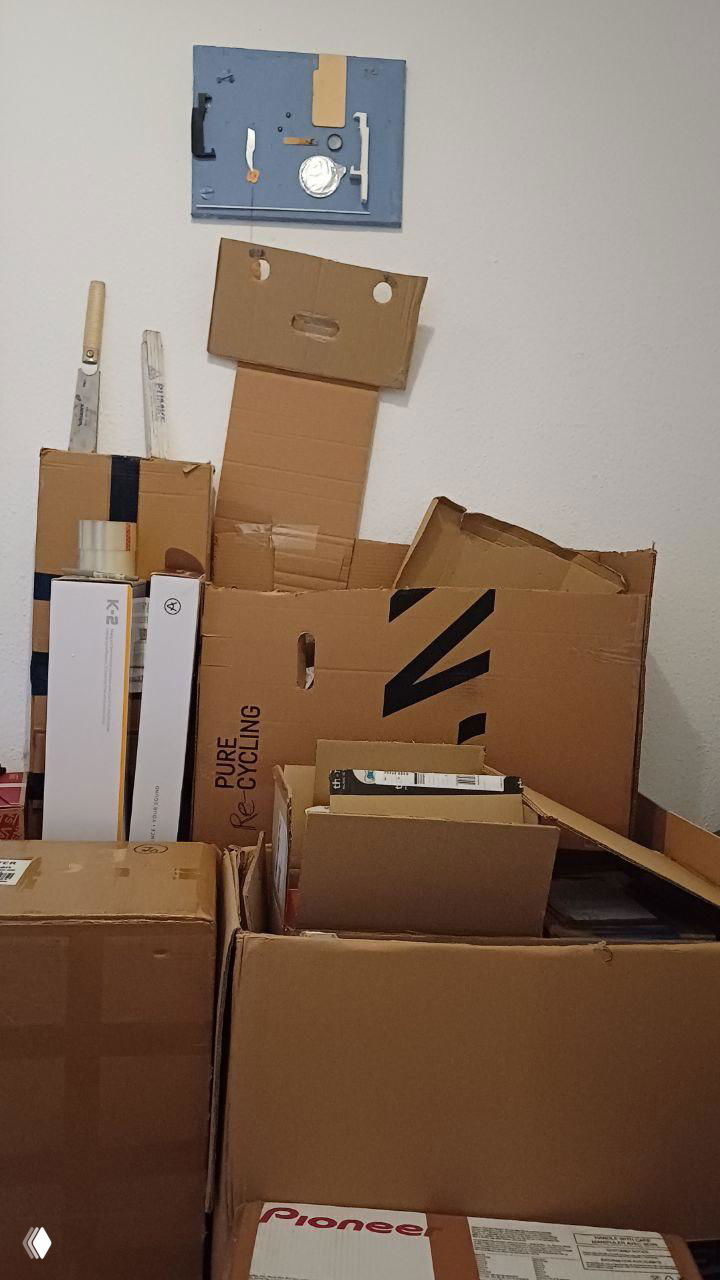 Стопка плоских и разложенных картонных коробок в комнате — запас упаковочных материалов для повторного использования и сборки индивидуальной упаковки.