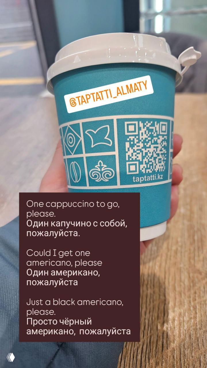 Бирюзовый бумажный стаканчик с крышкой и QR‑кодом, наклейка кафе и небольшой текстовый блок с примерами фраз для заказа кофе на английском и русском.