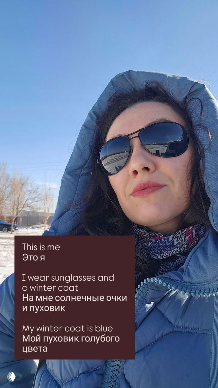 Селфи автора в солнечных очках и голубом пуховике на фоне зимнего пейзажа; в отражении очков видны воздушные шары и небо.