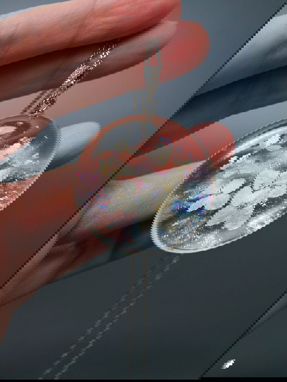 Бирюзовый кулон с голубыми лепестками и белой «дымкой» в смоле, эффектный контраст холодных оттенков и переливов на гладкой поверхности.