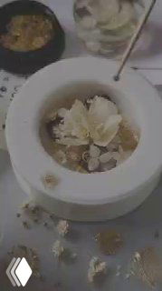 Крупный план процесса создания украшения: заливка смолы в круглый молд с сухоцветами и золотыми вставками на рабочем столе