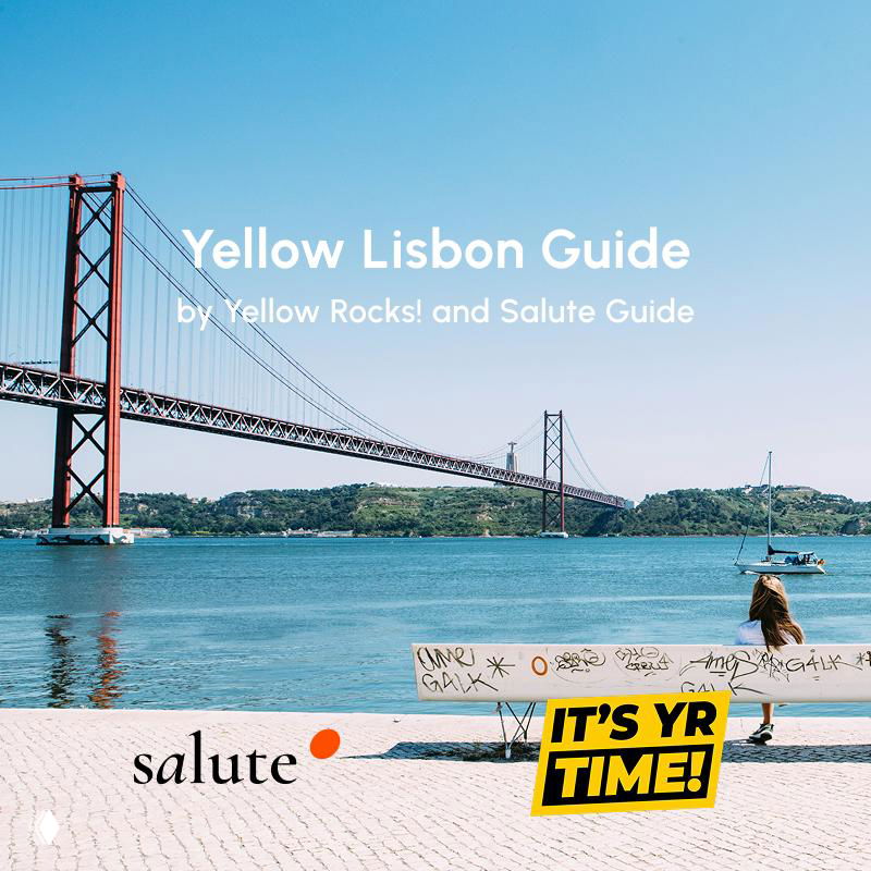 Lisbon waterfront with the 25 de Abril bridge in the background, a bench in the foreground and Salute/Yellow Lisbon Guide branding on the image.