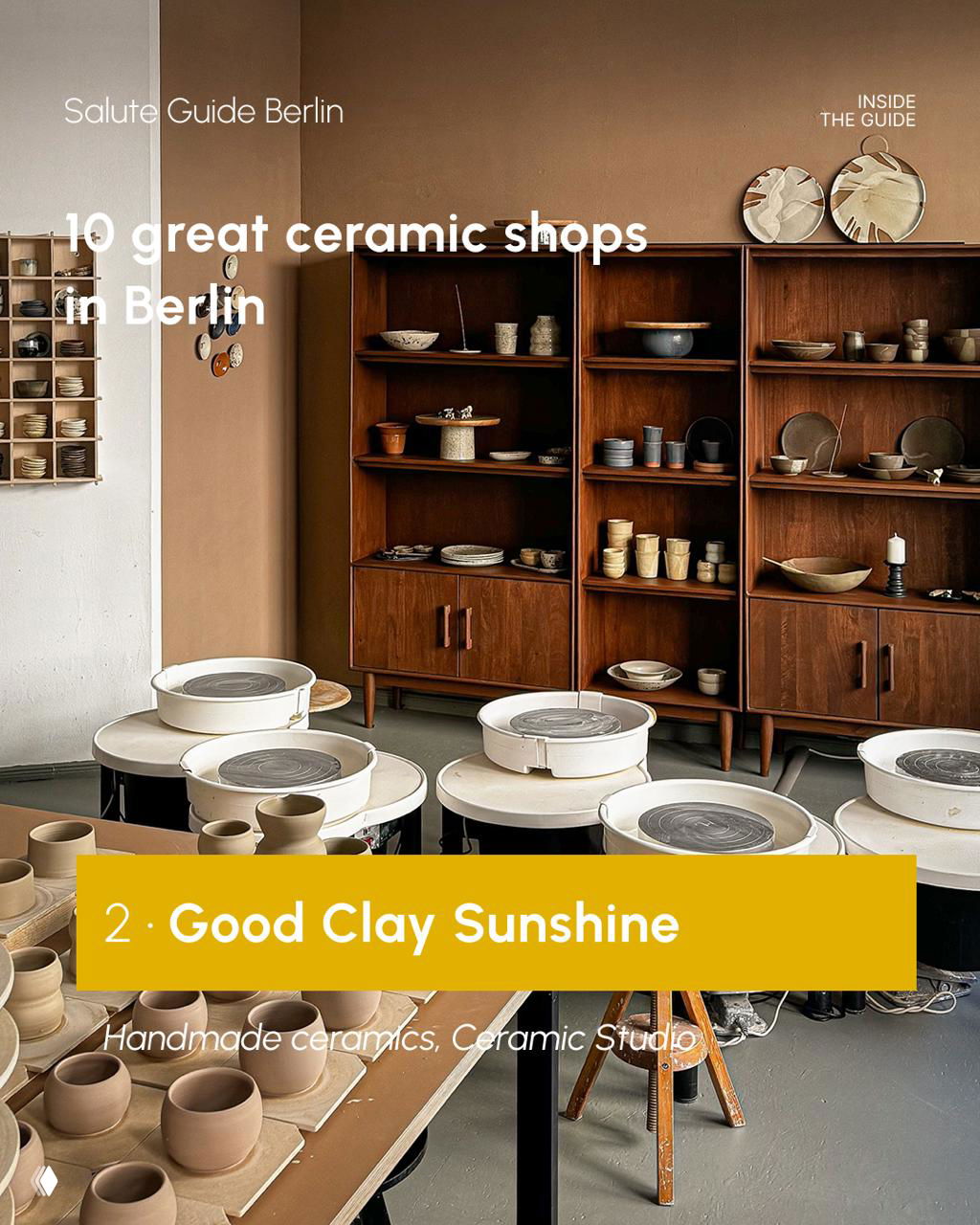 Interior view of a Berlin ceramic studio showing pottery wheels, wooden shelving and finished pots ready to be glazed; neutral tones and workshop feel.