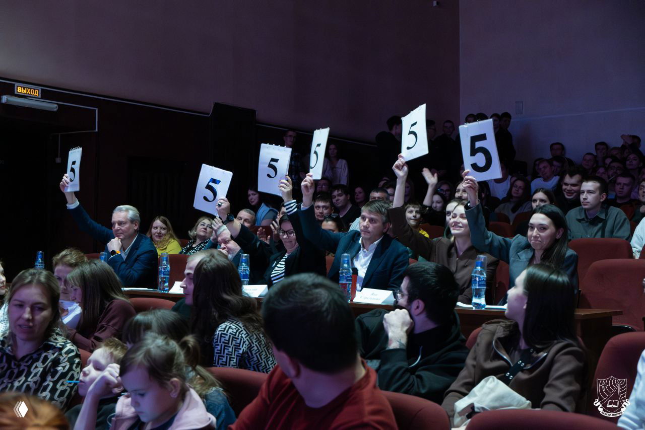 Зал и жюри во время финала Рязанской лиги КВН: члены жюри поднимают таблички с оценкой «5», в зале видна реакция зрителей и атмосфера шоу.