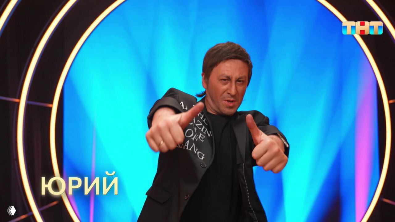 Юрий Леонтьев на фоне яркой кольцевой подсветки шоу «Ярче звёзд» (ТНТ): сценическая энергия, жесты исполнителя и телевизионная постановка номера.