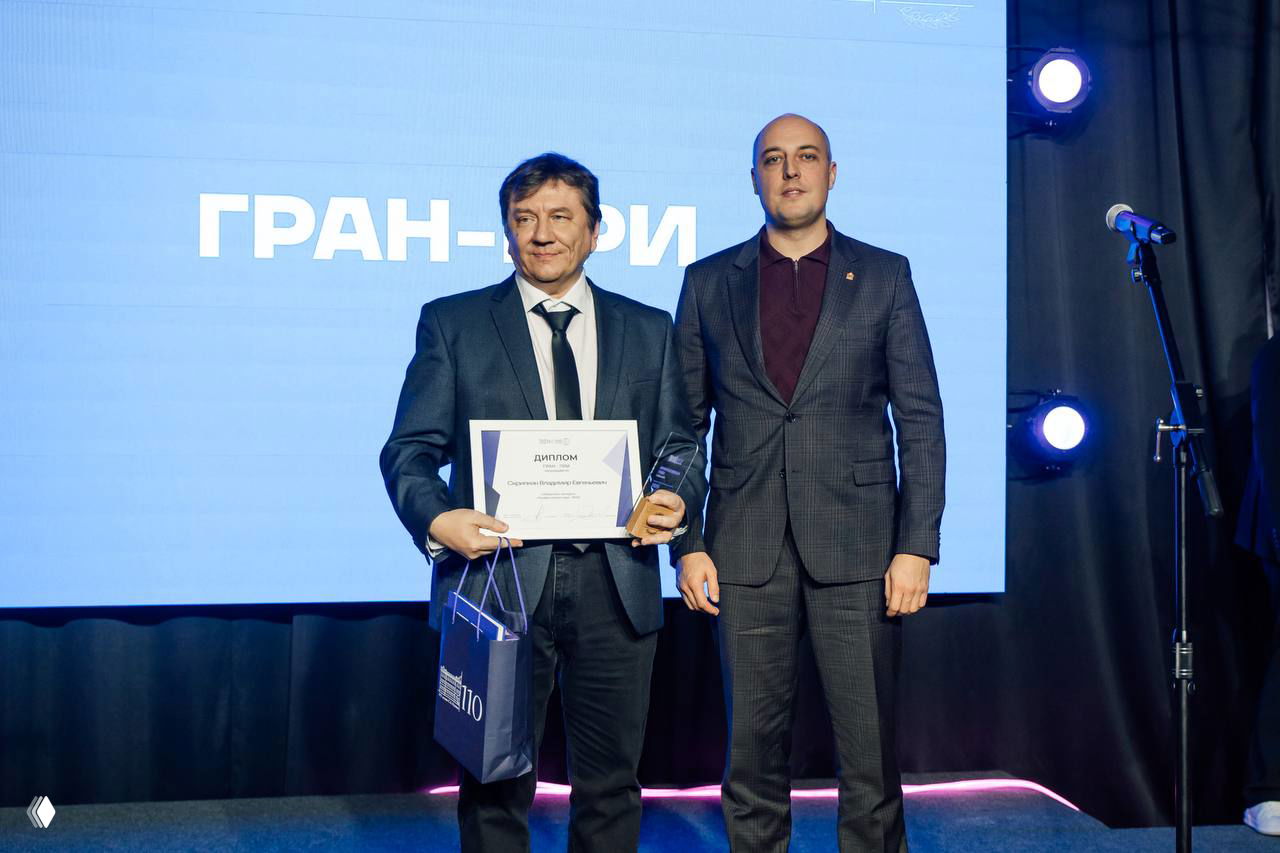 Владимир Скрипкин держит диплом и статуэтку Гран‑при на сцене церемонии «Профессионал года 2025» в Рязанском Доме молодёжи.