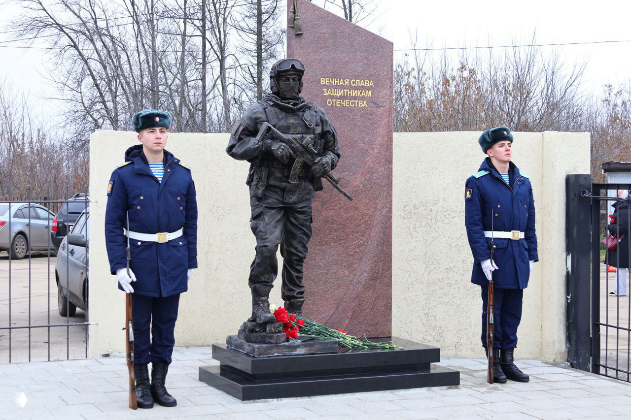 Памятник «Знамя и честь»: бронзовая фигура современного бойца, цветы у постамента и почётный караул на Богородском кладбище в Рязани.