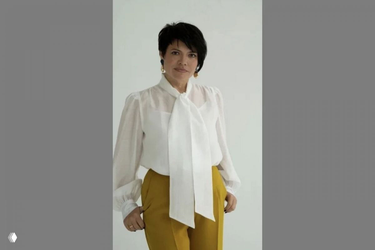 Портрет деловой женщины в белой блузке и горчичных брюках на светлом нейтральном фоне, фотография для профиля.