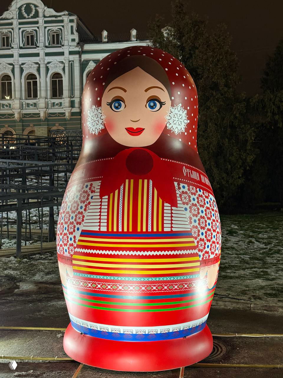 Фото сзади и в анфас матрёшки в полосатом и цветном сарафане, на покрытой тонким слоем снега аллее Лыбедского бульвара.