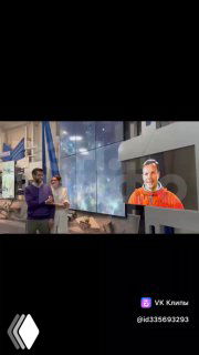 Фотография из Цифрового музея: молодожёны стоят у экрана, на котором отображён цифровой образ космонавта в форме.