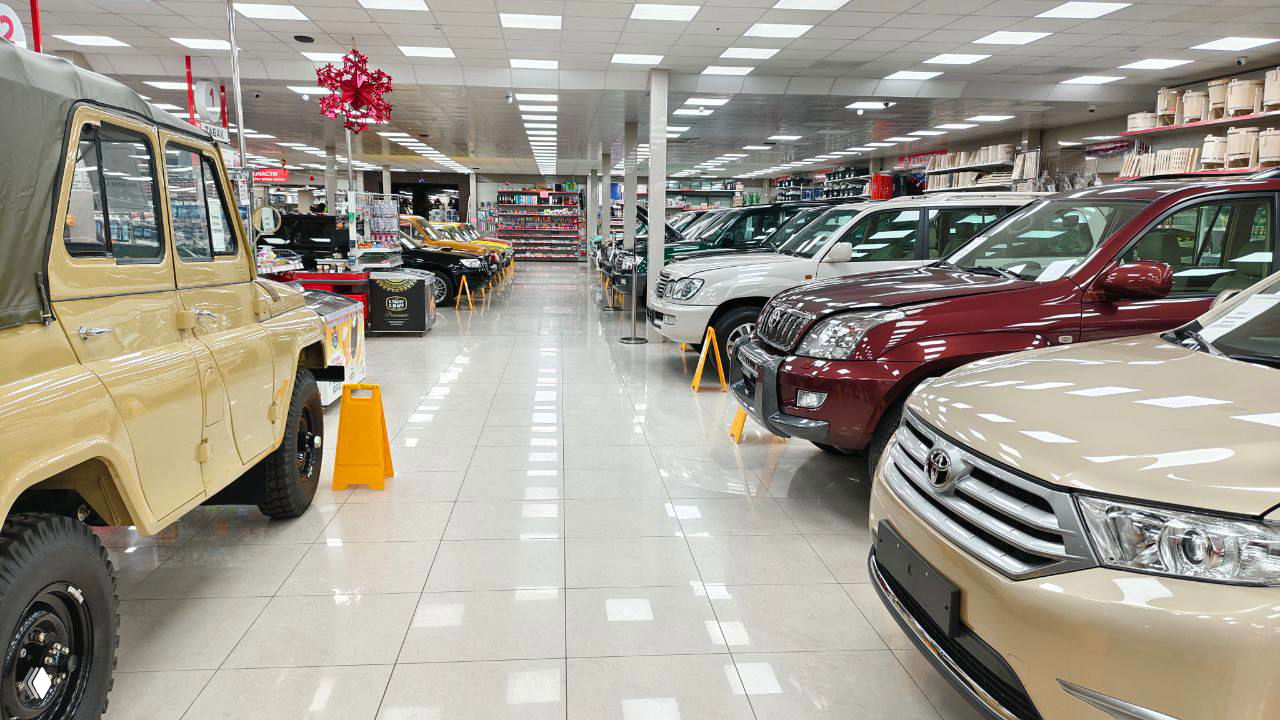 Общий вид торгового зала Горроща с выставленными ретро и современными автомобилями по обеим сторонам прохода, стеллажи и вещи на фоне, адрес ул. Островского, 101.