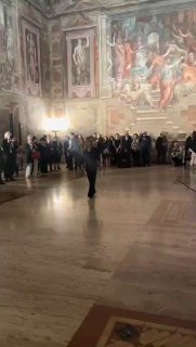 Перформанс «Walked Drawing» Линды Каршан в историческом интерьере: художник в центре зала очерчивает линии движением, публика по периметру.